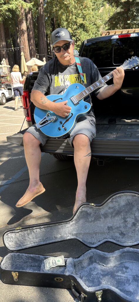 Rick Watson, Co-host and producer​. Rick playing the guitar on the back of a truck.
